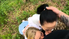 Two Girlfriends Suck Cock in the Wood